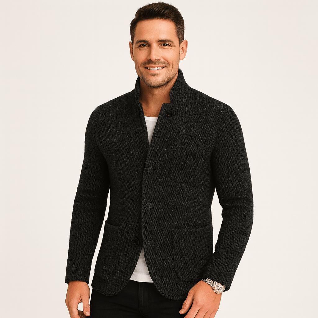 Man wearing a dark gray blazer on a light background