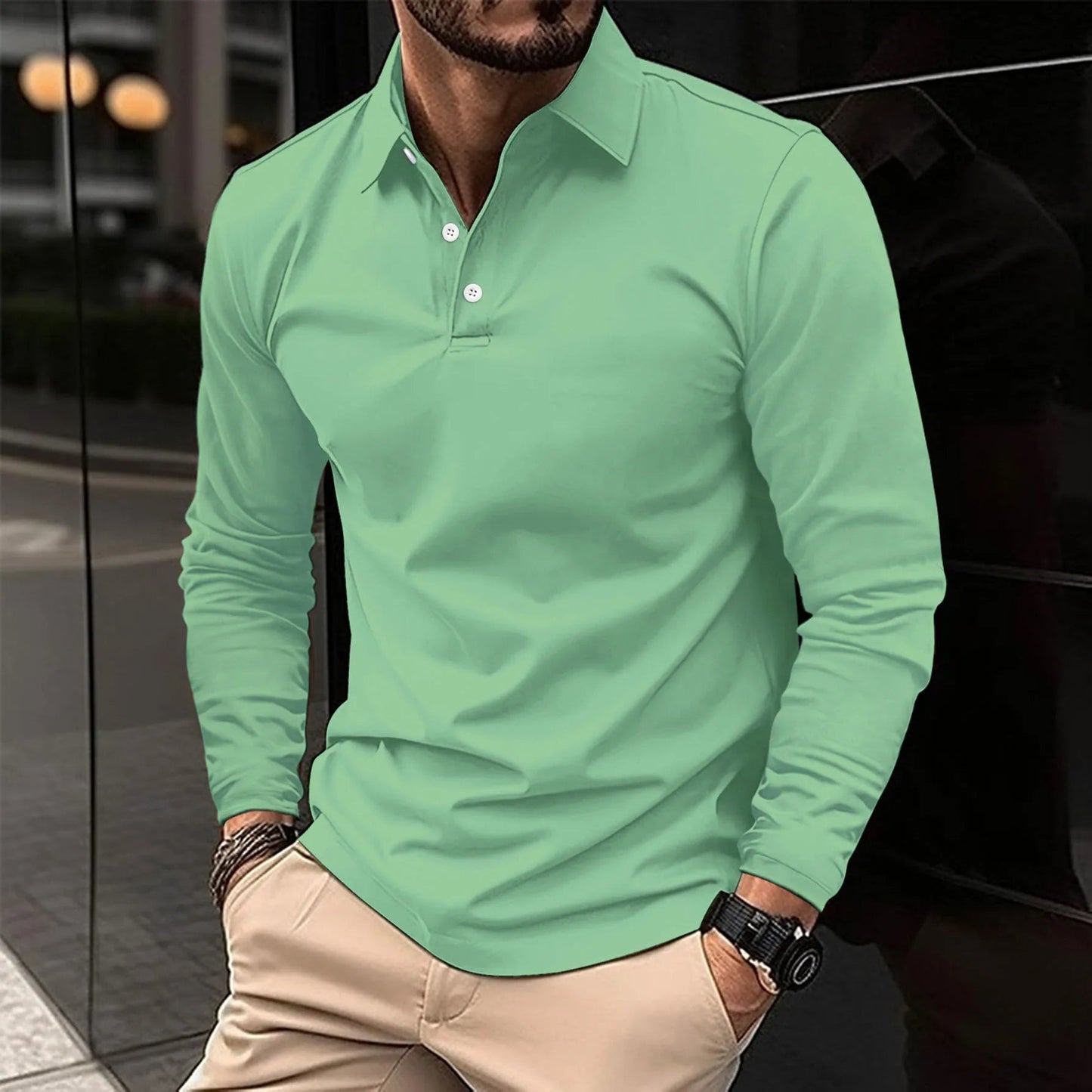 Man wearing a green long-sleeve polo shirt with beige pants.