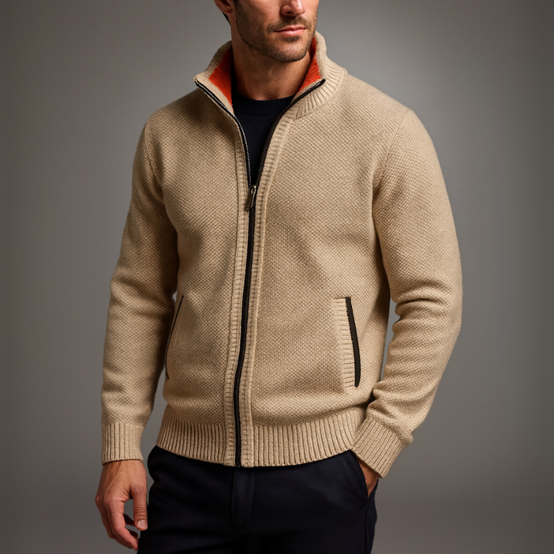 Man wearing a beige zip-up sweater against a gray background