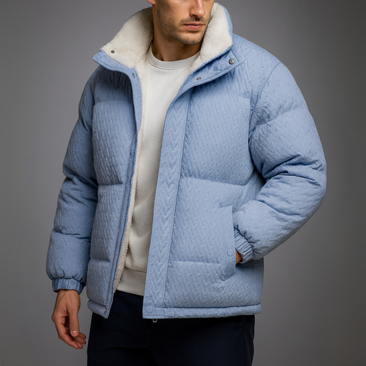 Man wearing a blue quilted jacket against a gray background