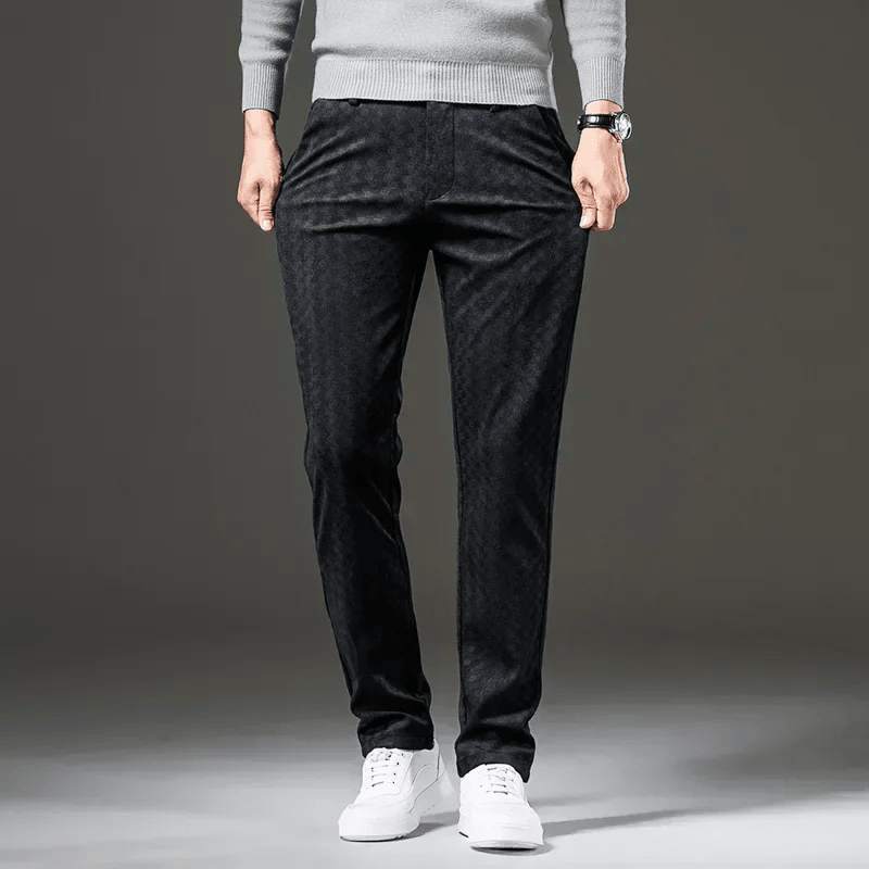 Person wearing black pants and a gray sweater on a gray background