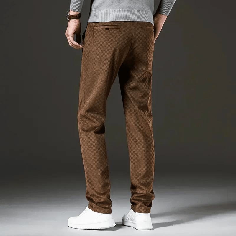 Brown patterned pants worn by a person on a dark background
