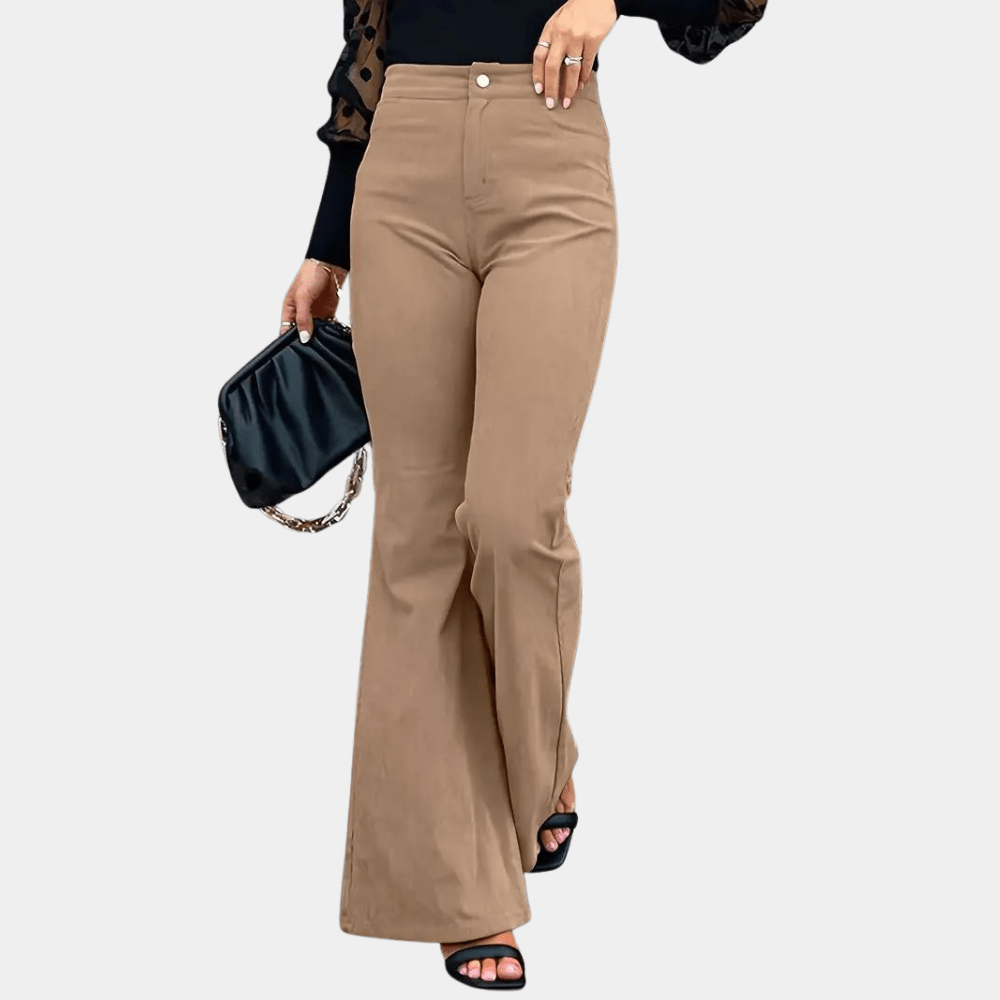 Person wearing beige pants holding a black clutch against a white background