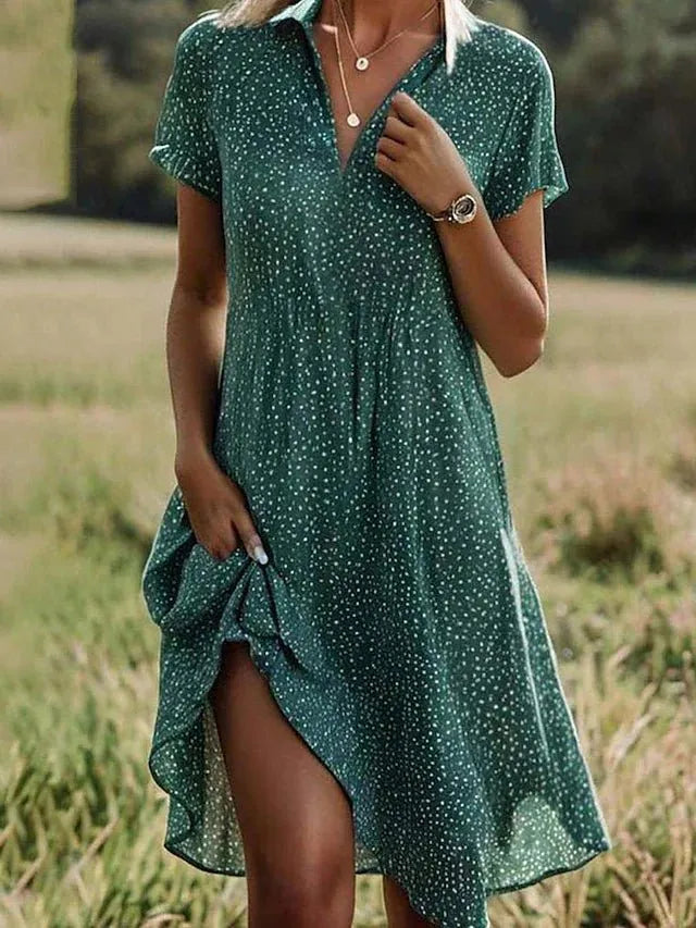 Woman wearing a green polka dot dress in a natural setting