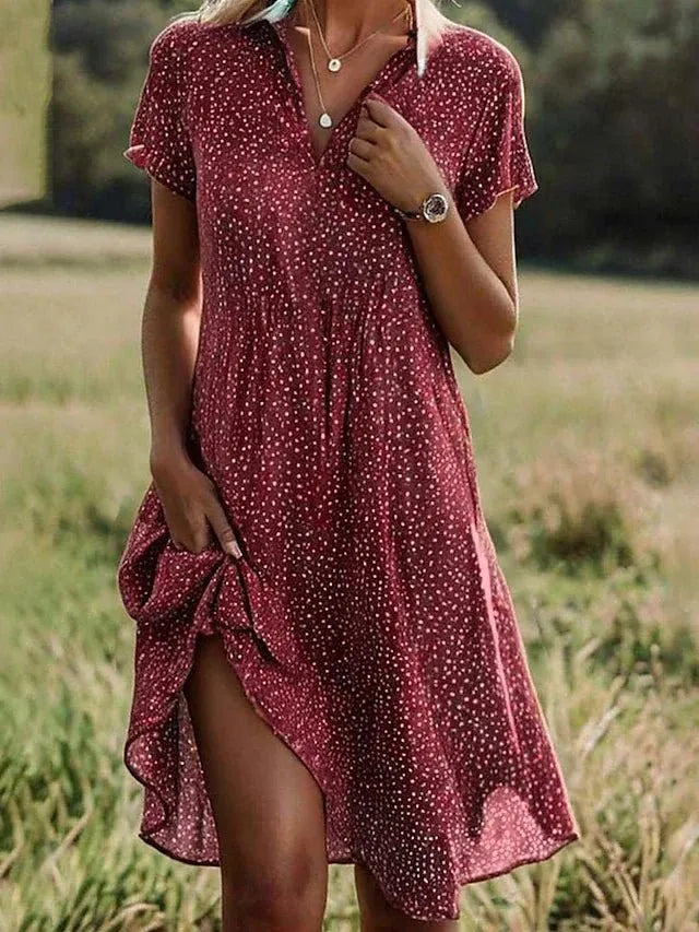 Woman wearing a burgundy polka dot dress in a field