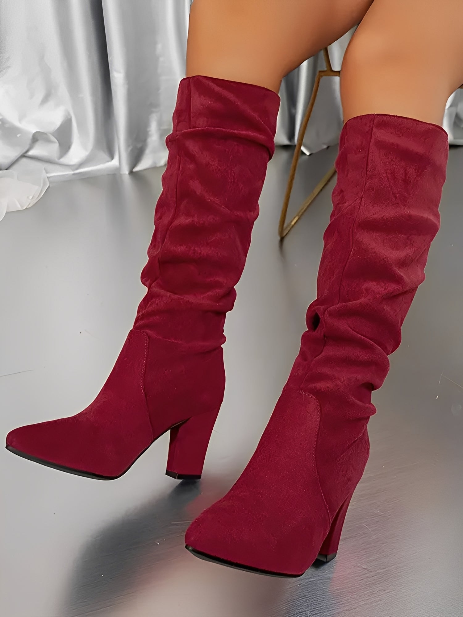 Red knee-high boots on a neutral background