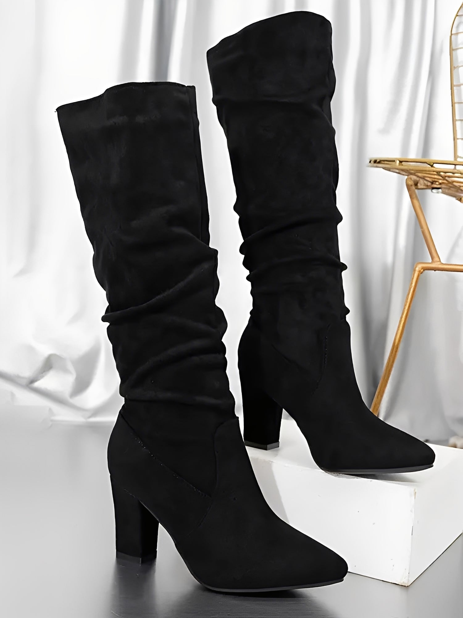 Black knee-high boots on a white background