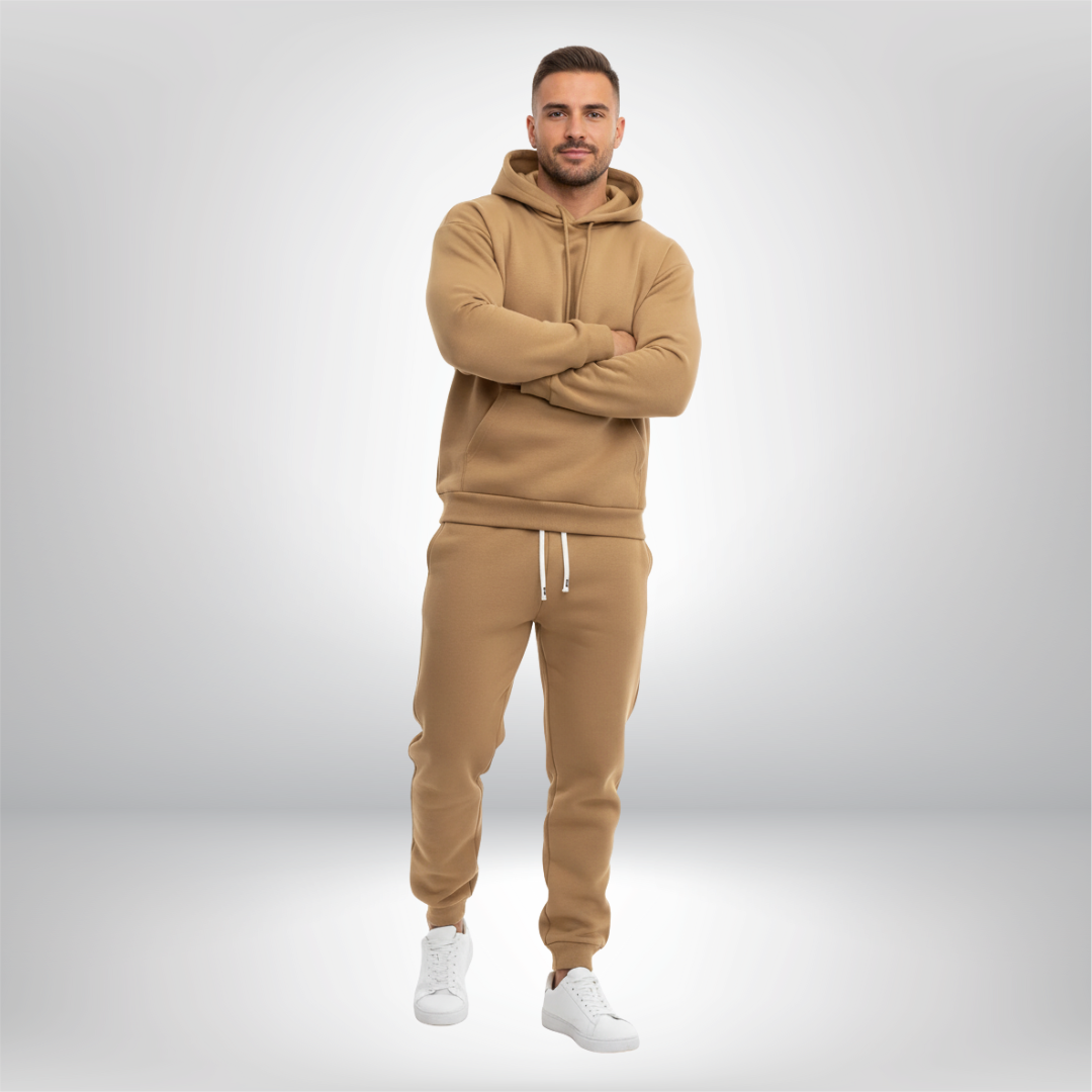 Man wearing a beige tracksuit with white sneakers on a light gray background