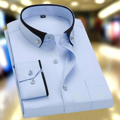 Light blue dress shirt with black collar and buttons on a blurred indoor background