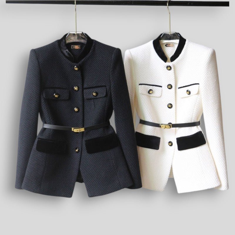 Two jackets, one black and one white, on hangers against a plain background.