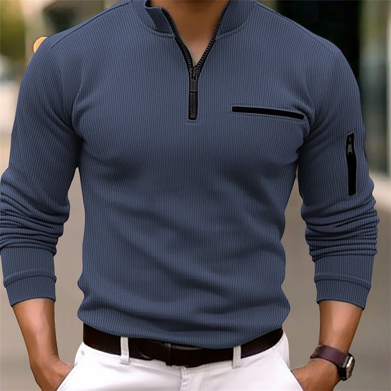 Blue long-sleeve shirt with zipper details worn by a person, blurred background