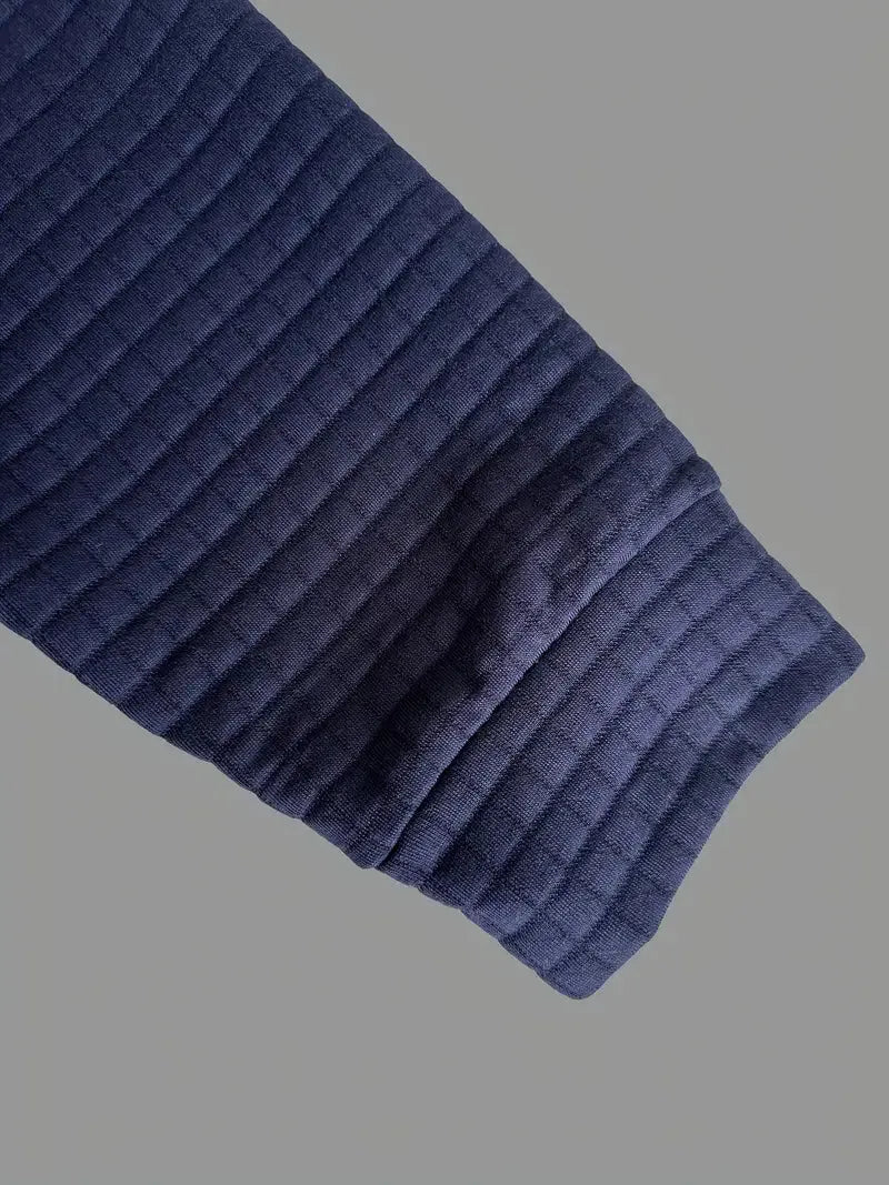 Navy blue ribbed knit sweater sleeve on a gray background