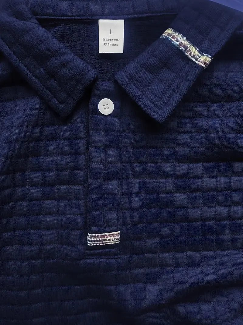 Navy quilted jacket with plaid trim and button detail, brand label visible.
