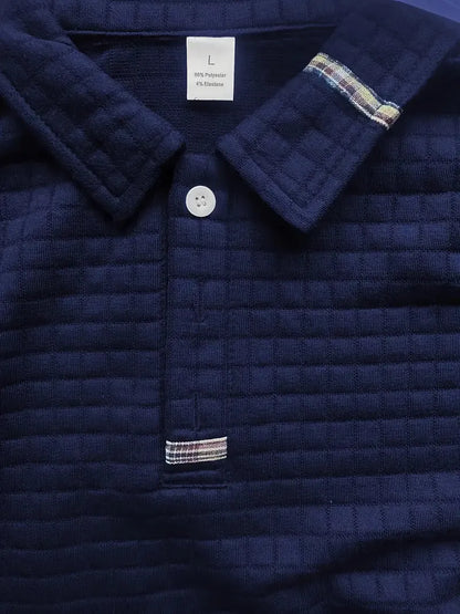 Navy quilted jacket with plaid trim and button detail, brand label visible.