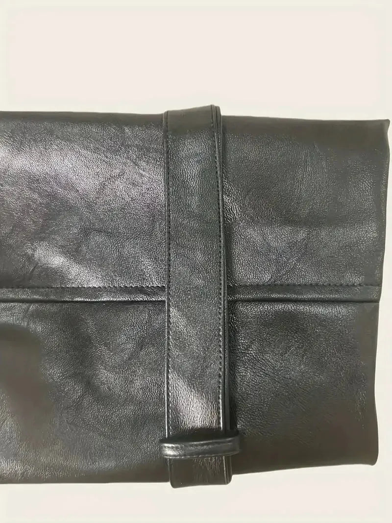 Black leather clutch bag on a light beige background