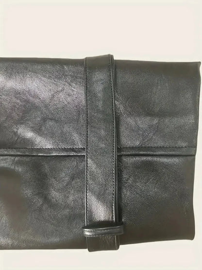 Black leather clutch bag on a light beige background