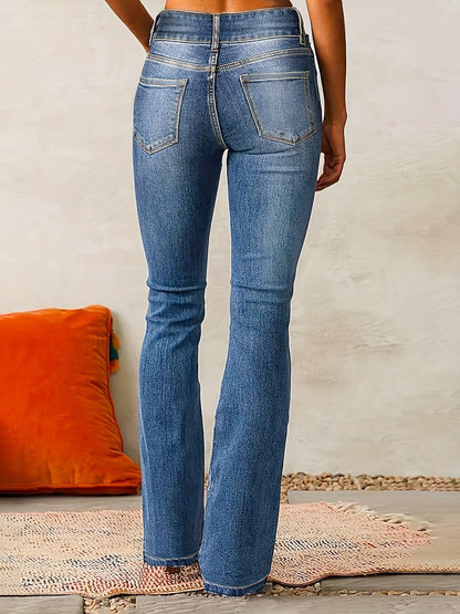 Person wearing blue jeans with a neutral background