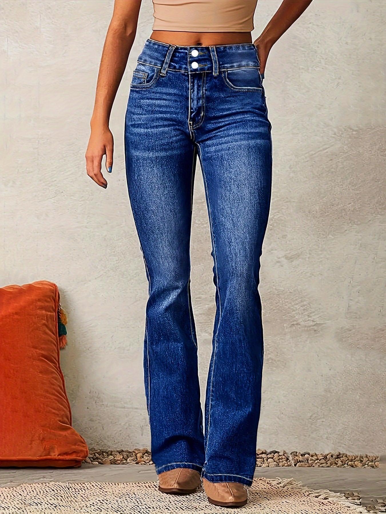 Person wearing blue jeans standing against a neutral wall with an orange pillow on the floor.