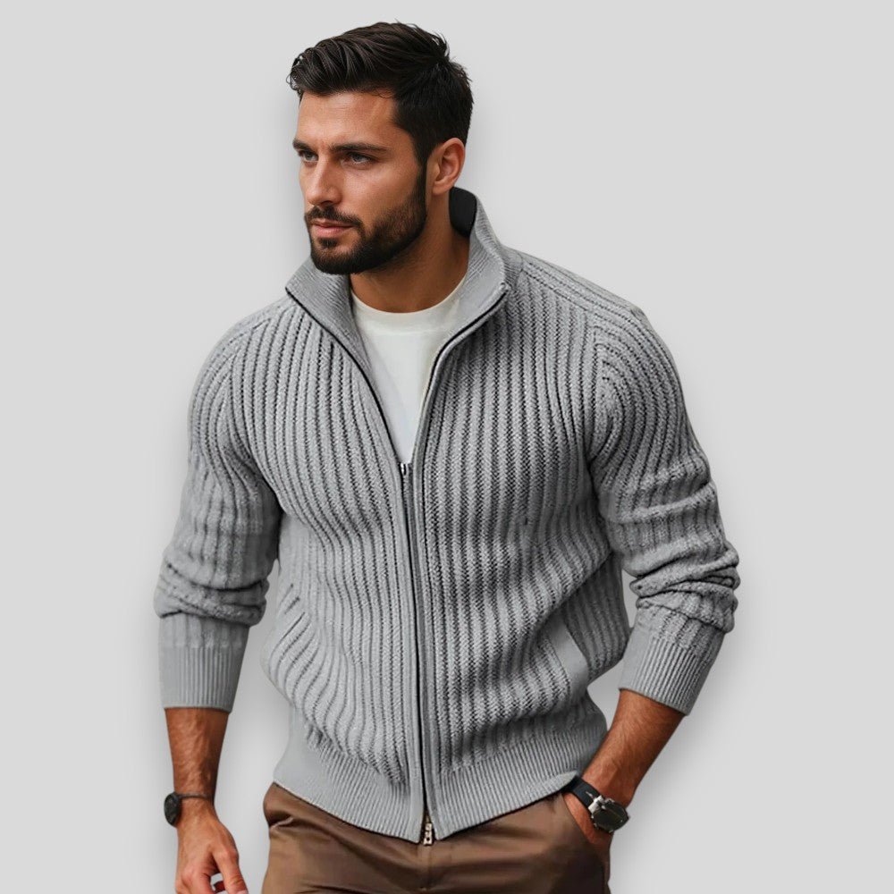 Man wearing a gray zip-up sweater against a light background