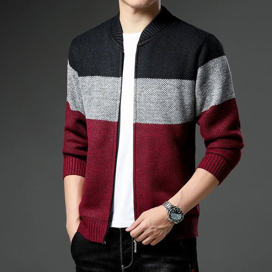 Person wearing a black, gray, and red striped sweater on a gray background