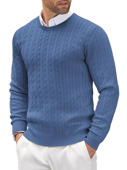 Man wearing a blue cable knit sweater with a white shirt underneath on a white background